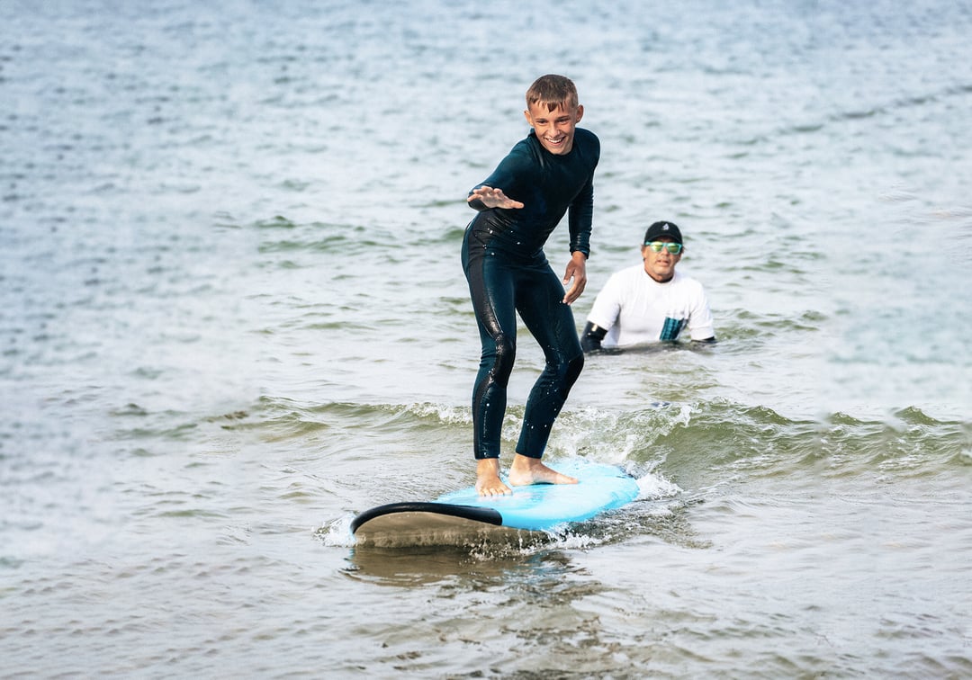 Dzieci niosące deskę surfingową